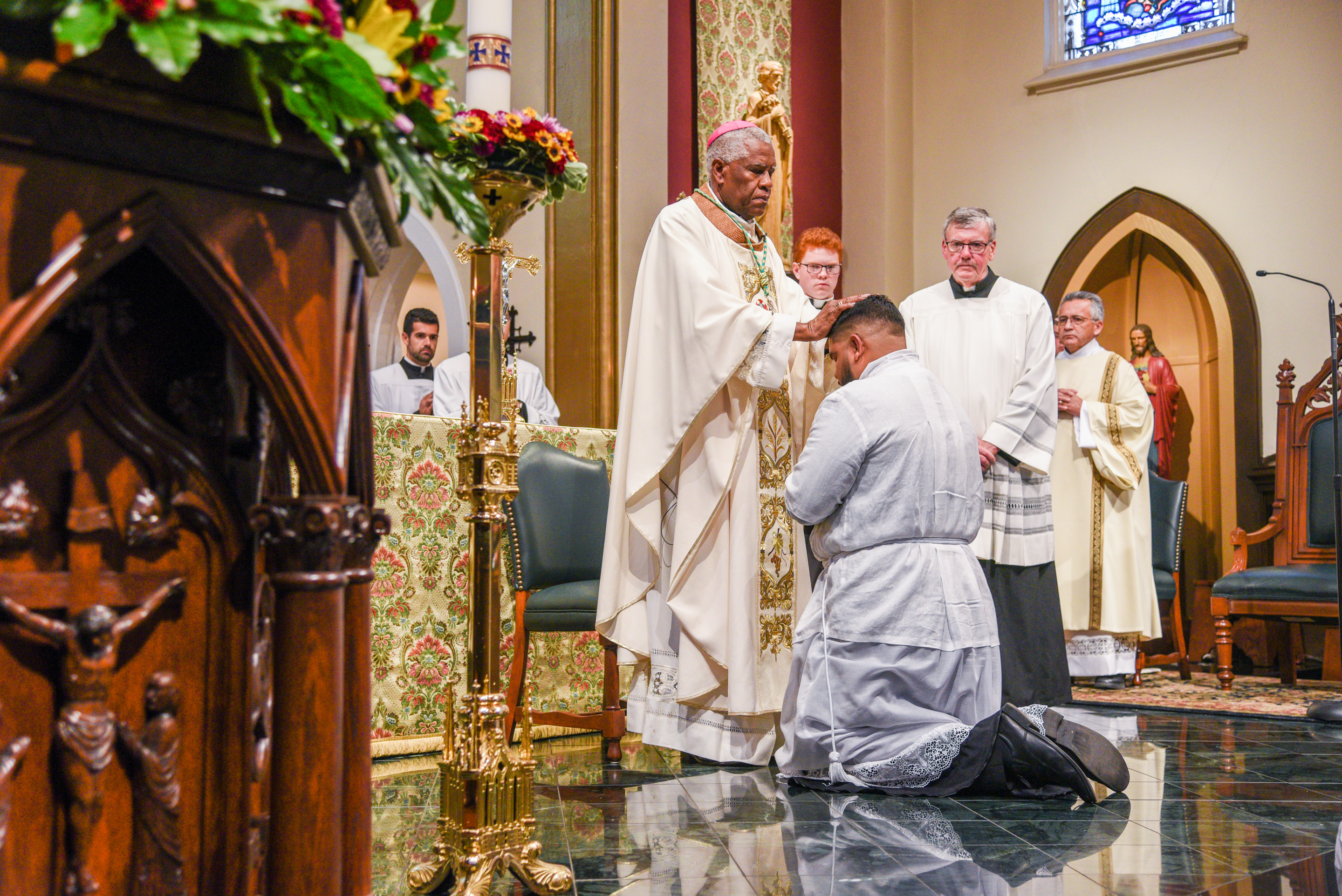 Bishop Fabre-Jeune laying hands upon Deacon Erik Roman