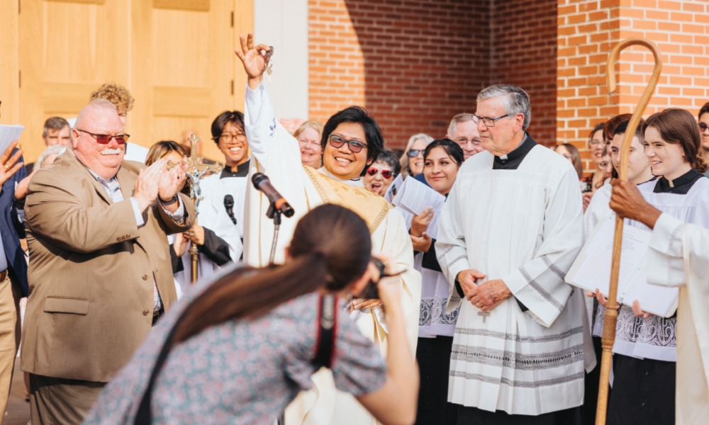 Father Giovannie Nunez raising the keys to the newly combined parishes of St. Anne and St. Jude