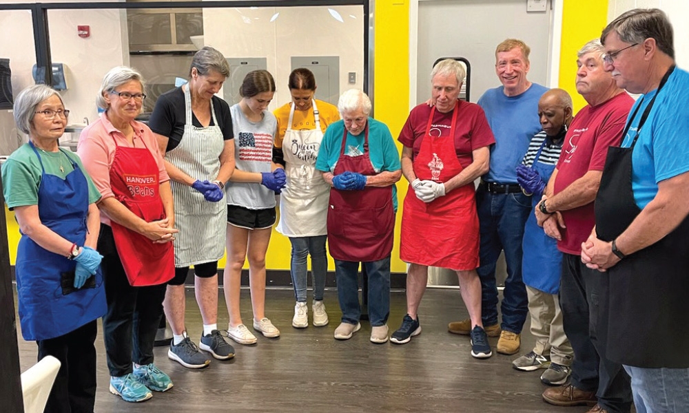 The Spartanburg soup kitchen volunteers praying before serving