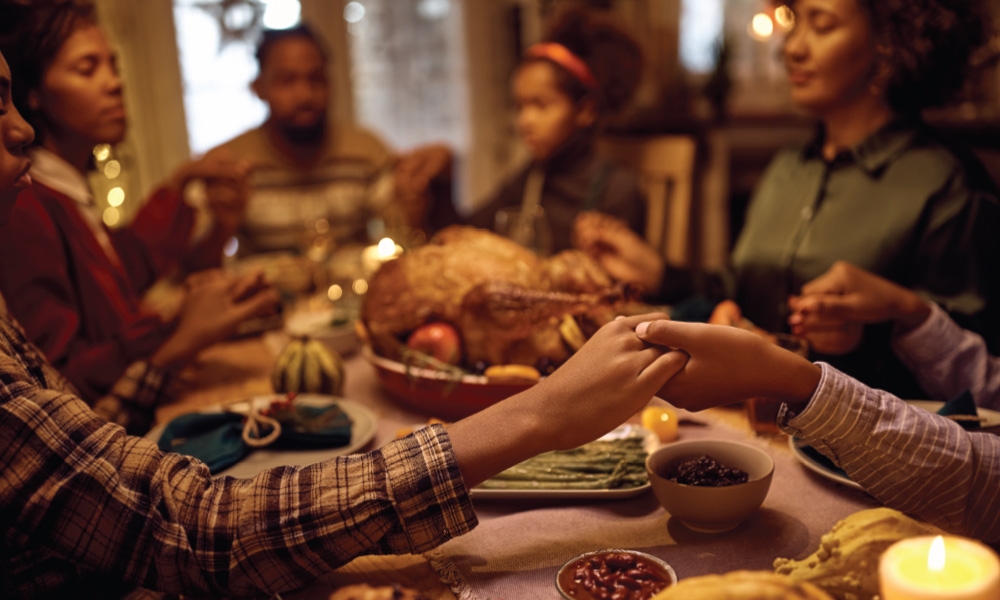 People praying at a Thanksgiving table
