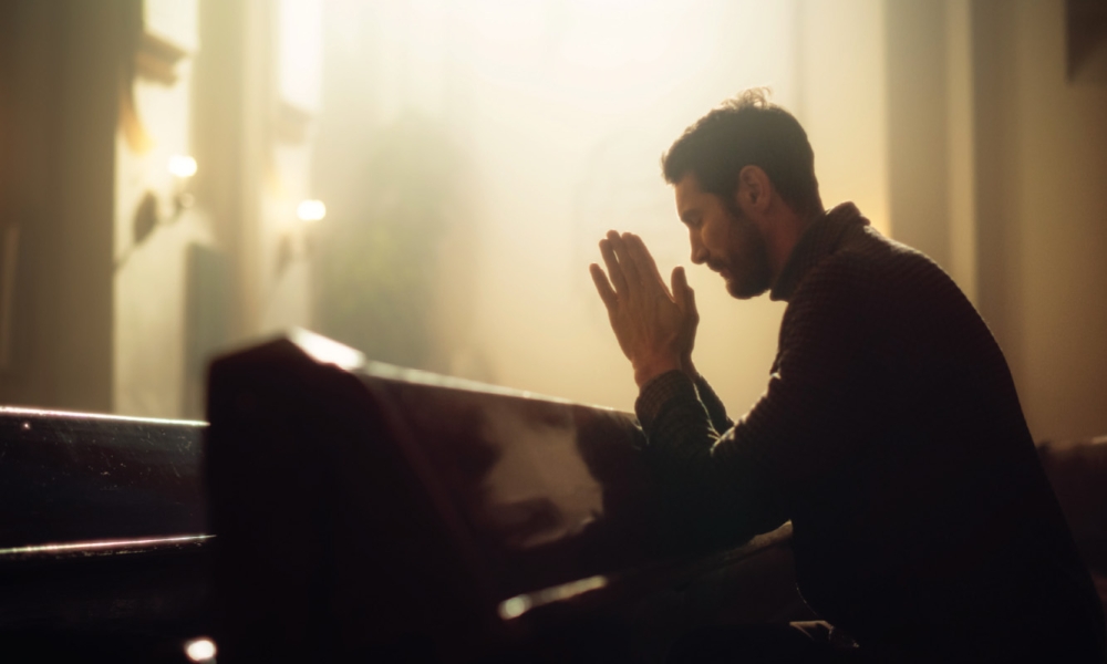 Man praying in a pew