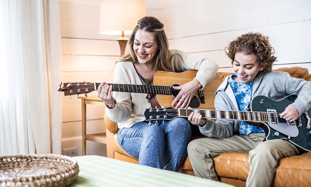 Mother and son playing guitar together