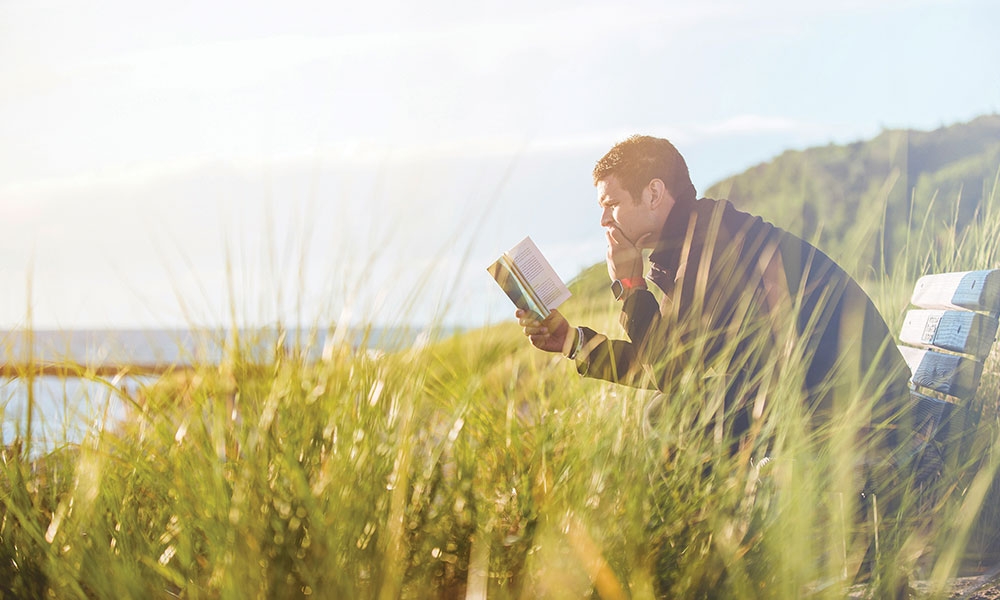 Man reading the Bible in a field