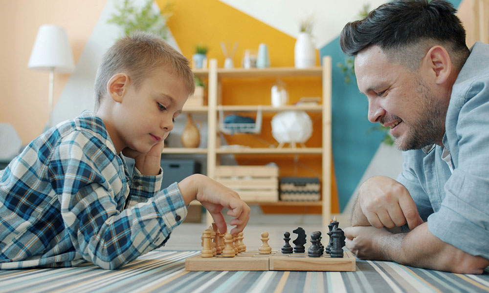 Father playing chess with son