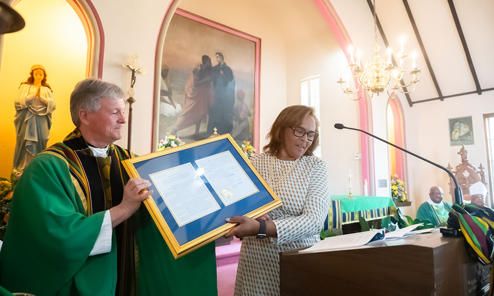 Father Bruce Barnett, pastor of St. James the Greater, receiving the proclamation issued for the parish's 200th anniversary.