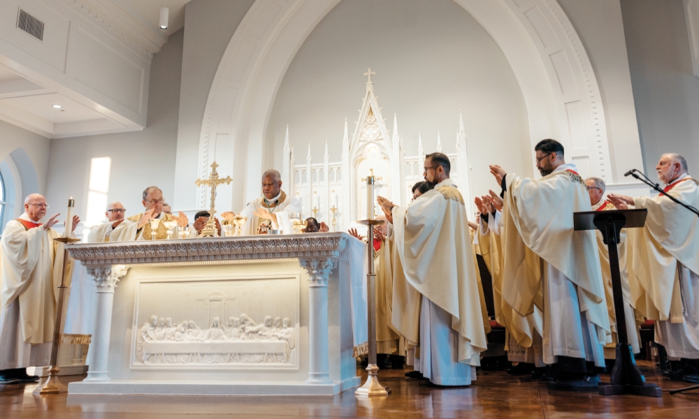Bishop Fabre-Jeune consecrating hosts, surrounded by priests