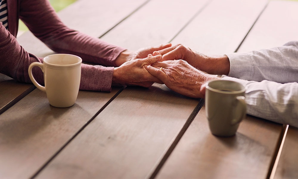 Elderly couple holding hands