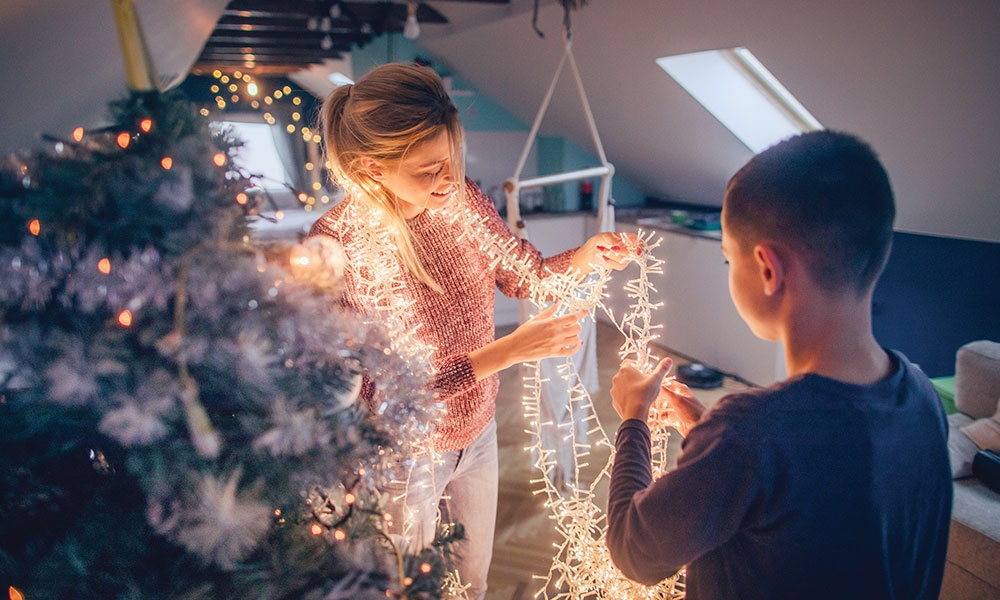 Two people untangling Christmas lights