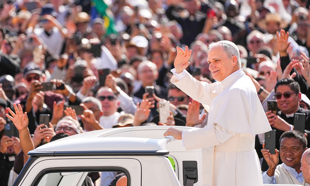 Pope Leo XIV greets the faithful while riding the popemobile