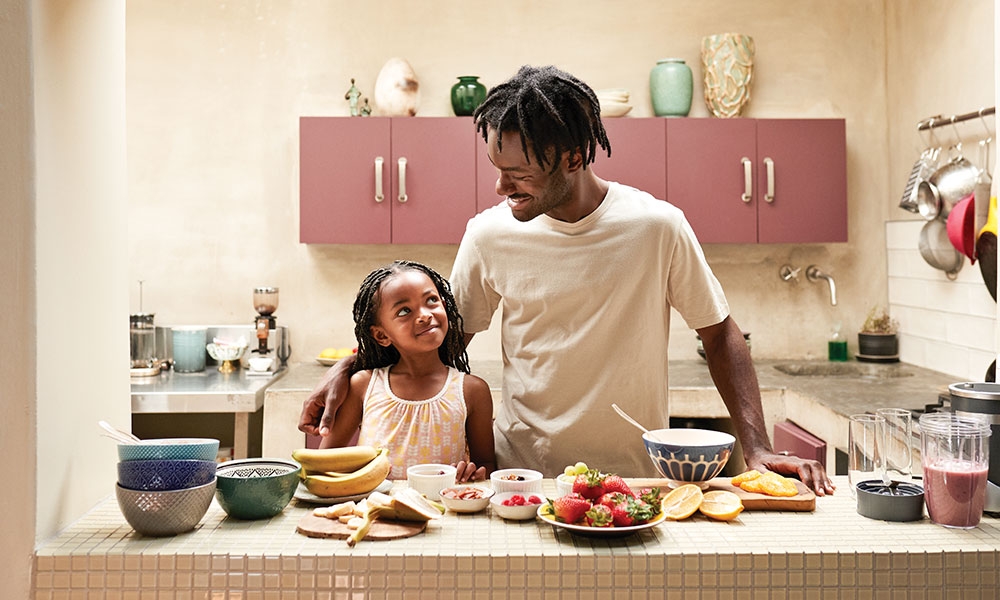 Man cooking in kitchen with young daughter