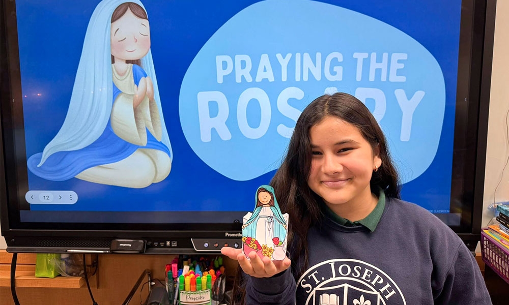 Catholic school girl holding an image of the Virgin Mary