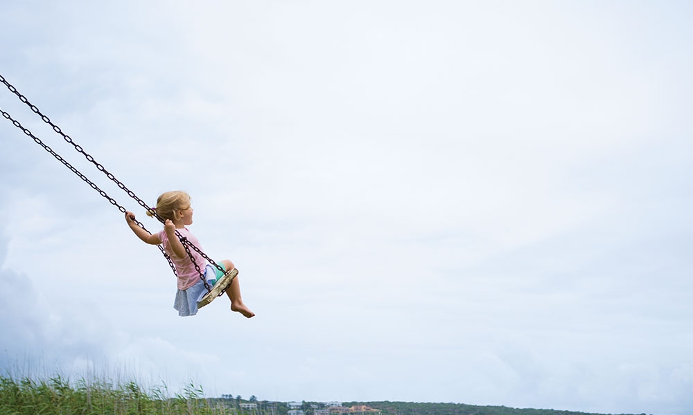 Little girl swinging on a swing